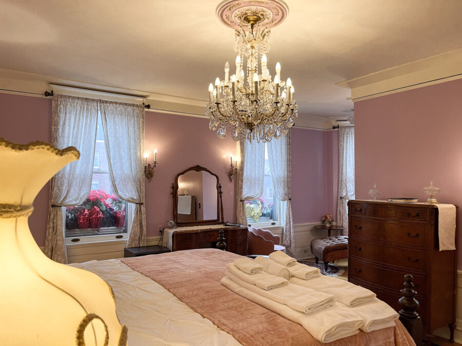 This huge room has an amazing chandelier over the bed